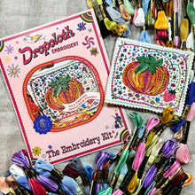 Load image into Gallery viewer, Dropcloth Embroidery Tea and Tomatoes Needle Book kit. Each kit includes sampler for one needlebook, instructions, threads, wool for the inside lining, one snap, one ribbon, and a free trial for a Creativebug class.