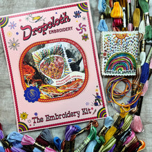 Load image into Gallery viewer, Dropcloth Embroidery Strawberry Needle Book kit. Each kit includes sampler for one needlebook, instructions, threads, wool for the inside lining, one snap, one ribbon, and a free trial for a Creativebug class. 
